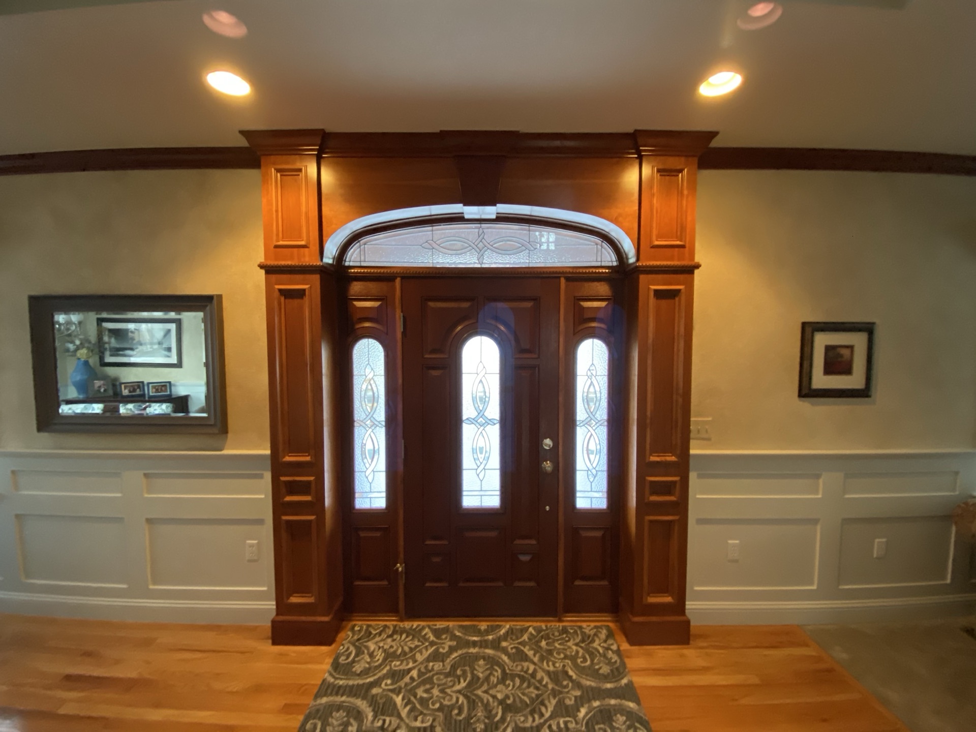 Grand foyer with custom mahogany entry door, stained glass, and arched transom
